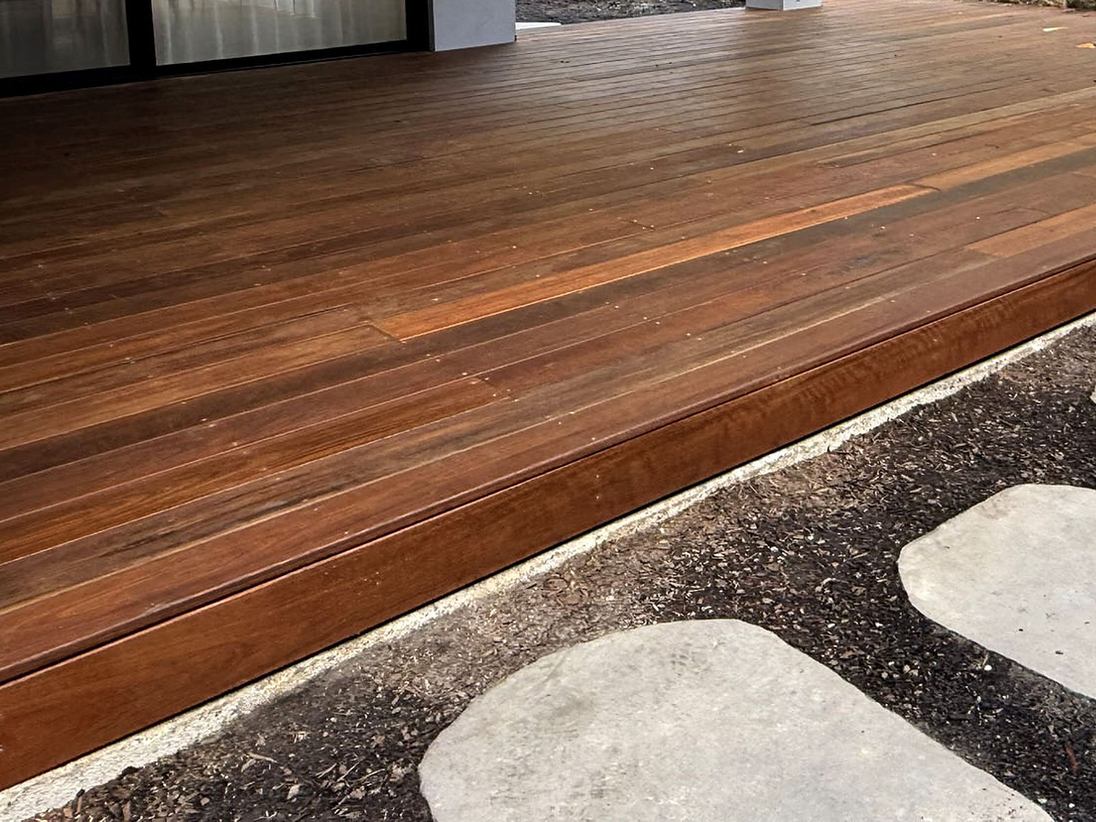 Close-up of spotted gum decking boards and step nosing, showing the colour depth of the Cutek penetrating sealer