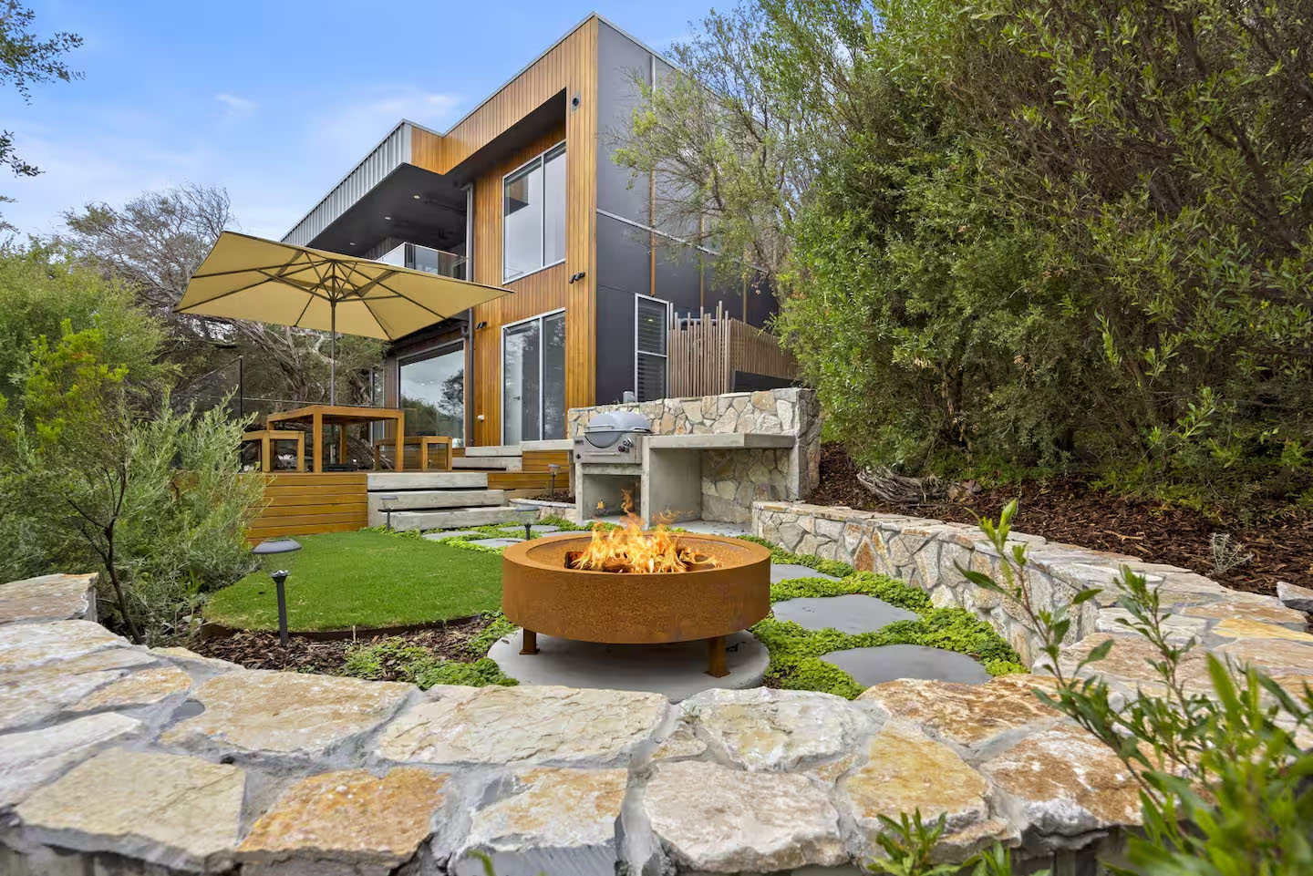 BMEL Landscapes — backyard with corten fire pit, stone walls and professional landscaping